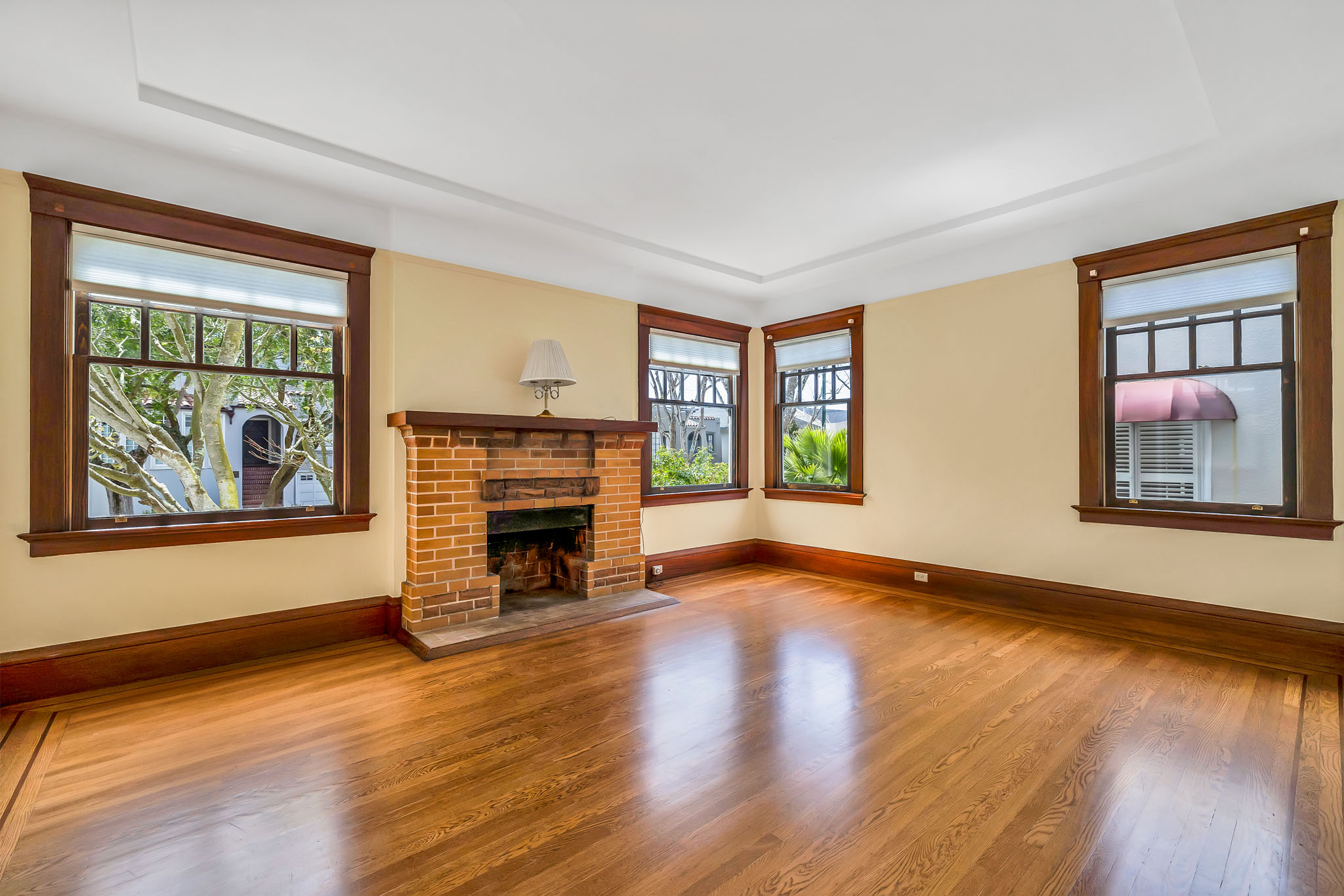 Living room of 554 Magellan with dark wood trim and brick fireplace